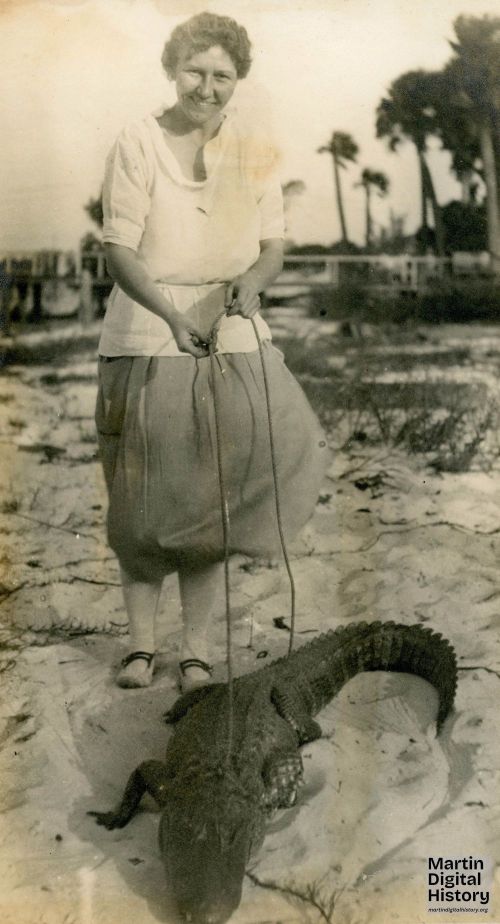 Edith Coventry holding open the mouth of an alligator. Labeled May 23, 1922.